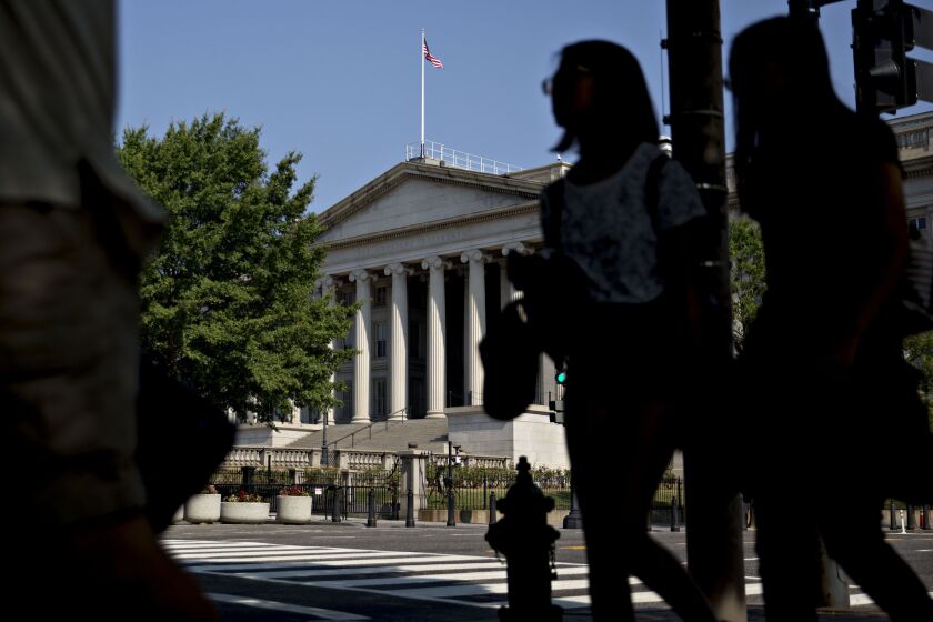 Pedestrians walk near the U.S. Treasury building in Washington, D.C.