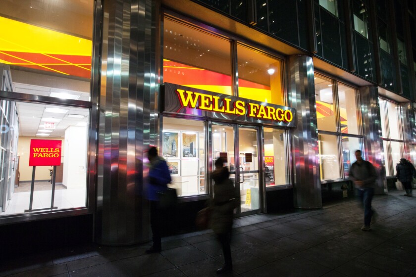 Pedestrians pass in front of a Wells Fargo & Co. bank branch in New York, U.S., on Tuesday, Jan. 9, 2018. Wells Fargo & Co. is scheduled to release earnings figures on January 12. Photographer: Daniel Tepper/Bloomberg