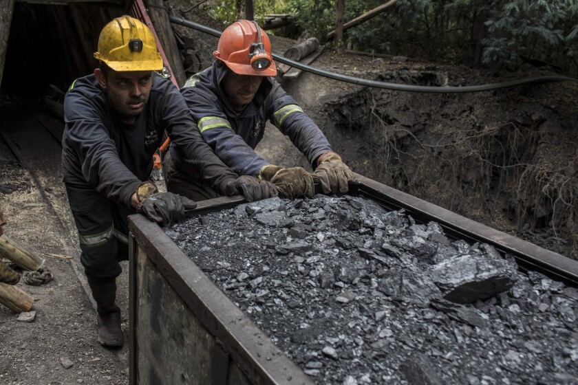 Miners push a wagon of coal outside a mine in Cucunuba, Cundinamarca Department, Colombia, on Friday, July 28, 2017. Colombia is set to produce a record of more than 90 million tons of the fossil fuel this year, its biggest export after oil. Colombia continues to bet on coal, even as global demand tapers off because the world is switching to cleaner fuels. Photographer: Nicolo Filippo Rosso/Bloomberg