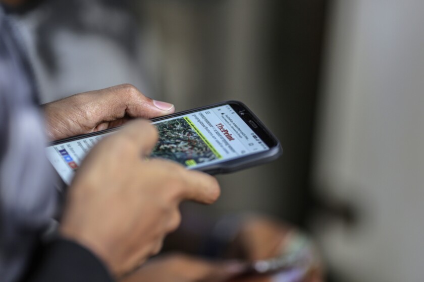 A man reads a news article on a smartphone in Mumbai, India, on Friday, March 28, 2019. Based on the early tallies, as many as 60 percent of India’s 900 million eligible voters are expected to cast ballots between now and May 19, as the center-left Congress Party tries to seize power from the right-wing Bharatiya Janata Party. As in other elections around the world, paid hacks and party zealots are churning out propaganda on Facebook Inc. and the company's WhatsApp messenger, along with Twitter, YouTube, TikTok, and other ubiquitous communication channels. Photographer: Dhiraj Singh/Bloomberg