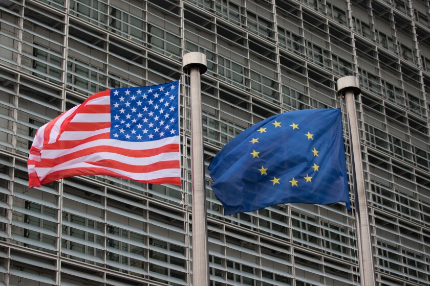 The U.S. flag flies beside a European Union flag outside the European Commission building in Brussels.