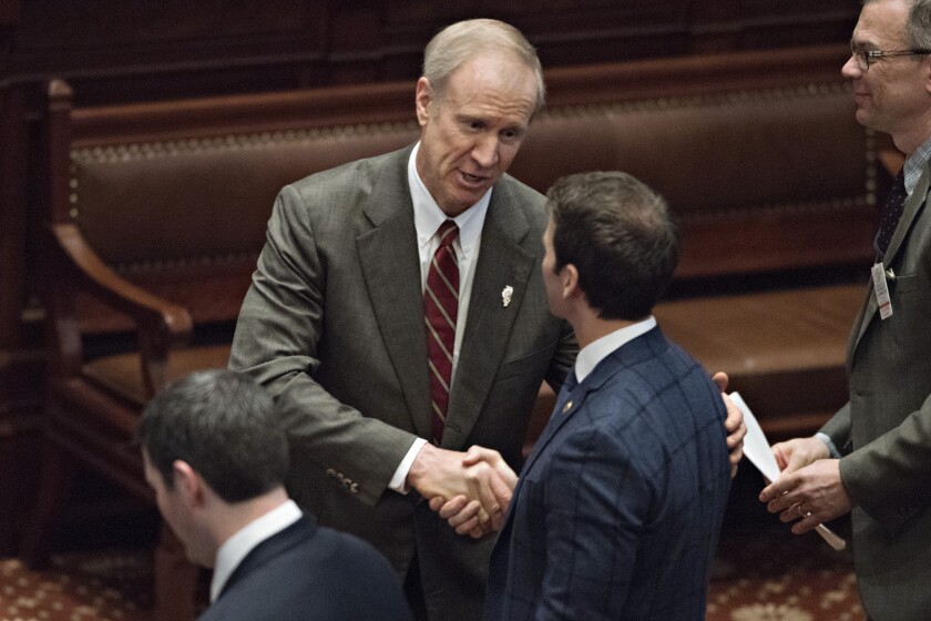 Bruce Rauner, governor of Illinois, center, greets an attendee on the floor of the House Chamber at the State Capitol building.
