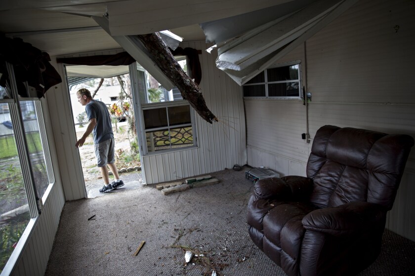 A resident surveys the damage to his trailer after a tree punctured the roof at the Camp Inn RV Park in Frostproof, Florida, during Hurricane Irma.