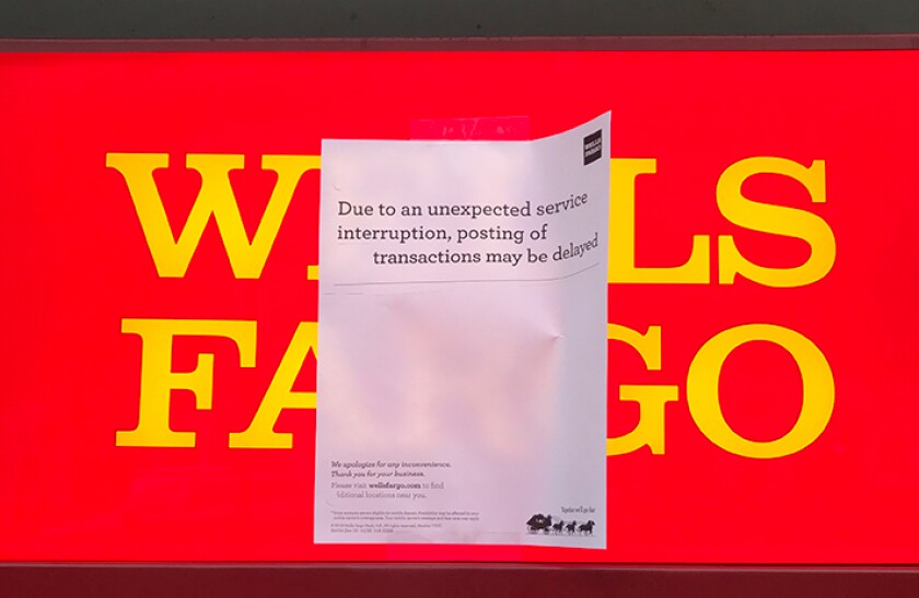 Sign posted on a Wells Fargo ATM alerted customers to potential transaction delays.