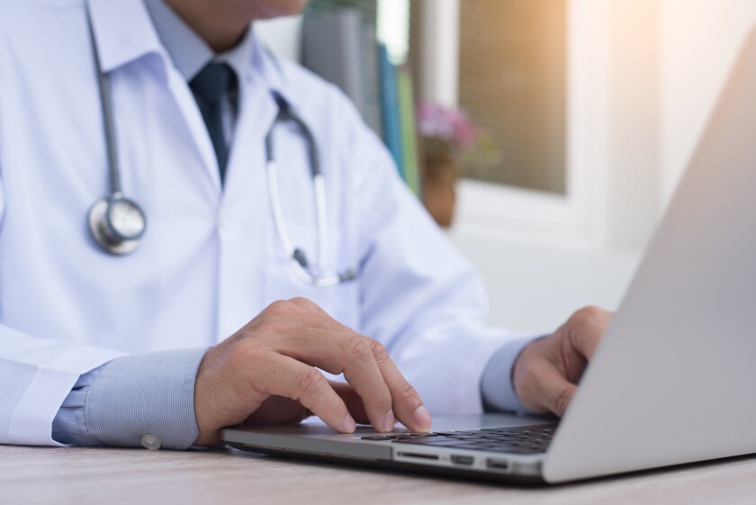 Doctor working on laptop male closeup.jpeg