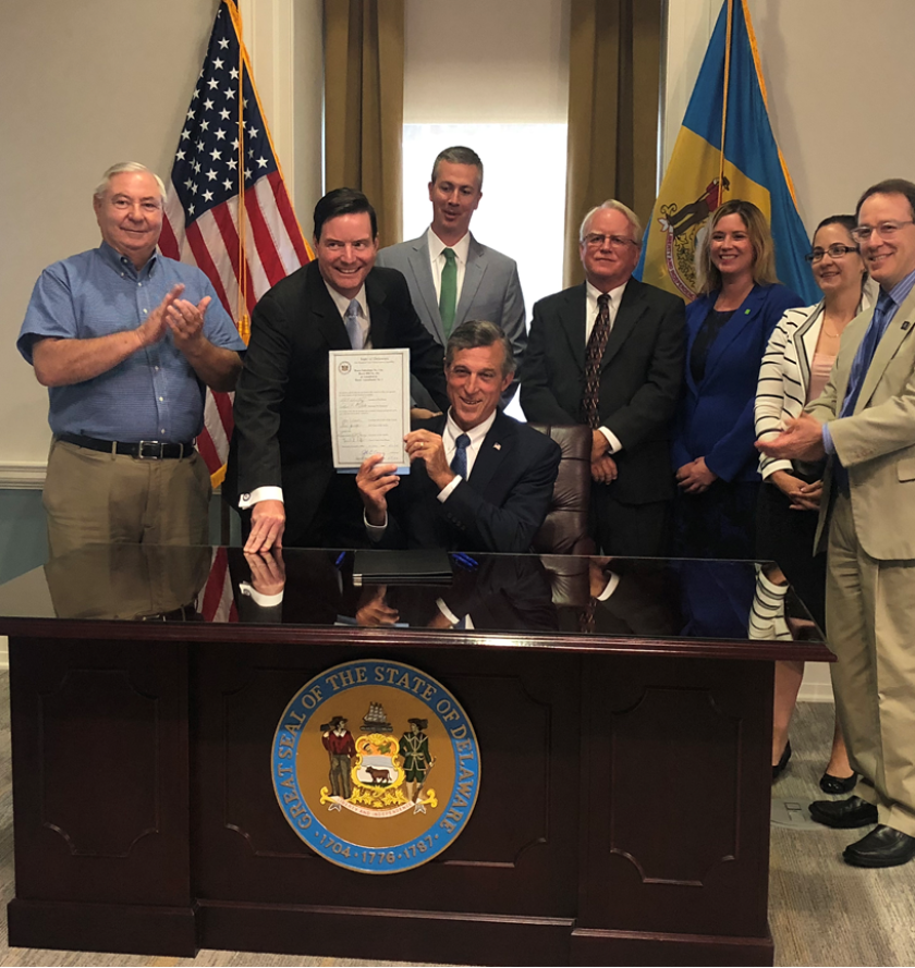 Delaware Governor John Carney displays the Taxpayer Protection Act he signed into law