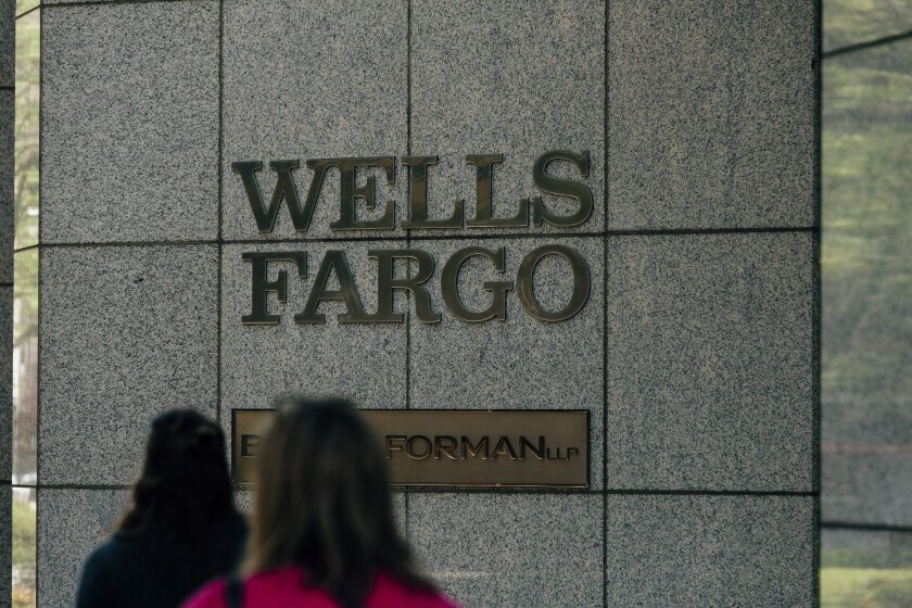 Pedestrians pass in front of the Wells Fargo & Co. corporate office in Birmingham, Alabama, U.S., on Wednesday, April 11, 2018. Wells Fargo & Co. is scheduled to release earnings figures on April 13. Photographer: Wes Frazer/Bloomberg