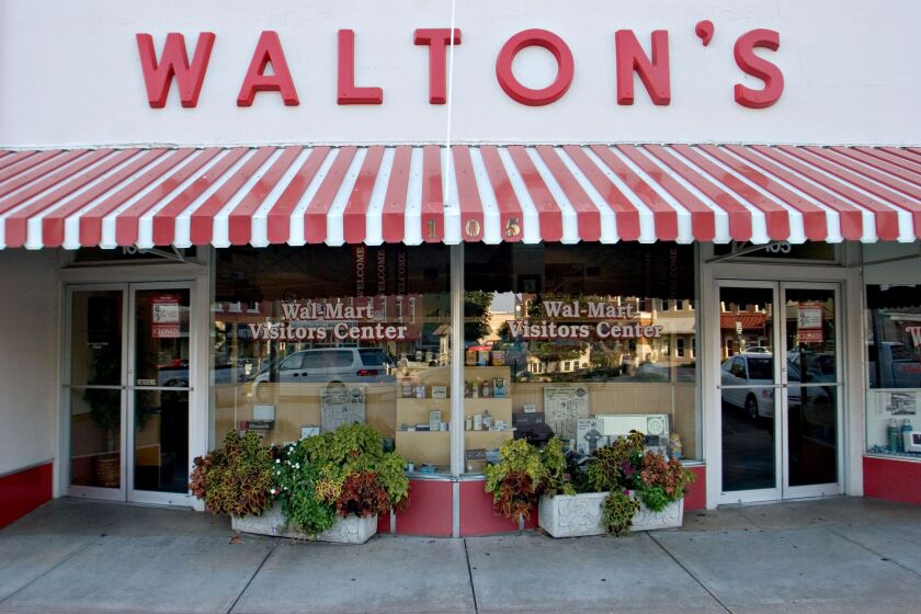 A sign for Walton's 5&10, the forerunner to today's Wal-Mart stores, hangs above what now serves as the Wal-Mart Visitors Center in Bentonville, Arkansas, U.S. Thursday, Sept. 20, 2007. The Walton's store was opened by Sam Walton on May 9, 1950. Photographer: JB Reed/ Bloomberg News