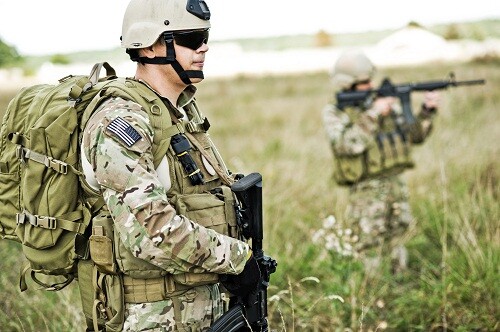 Soldiers in full gear patrol the area in the desert