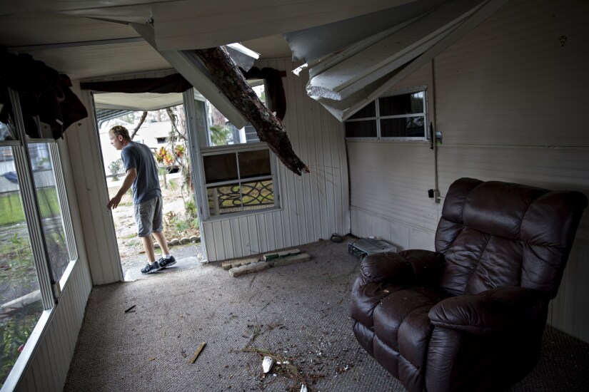 A resident surveys the damage to his trailer after a tree punctured the roof at the Camp Inn RV Park in Frostproof, Florida, during Hurricane Irma.