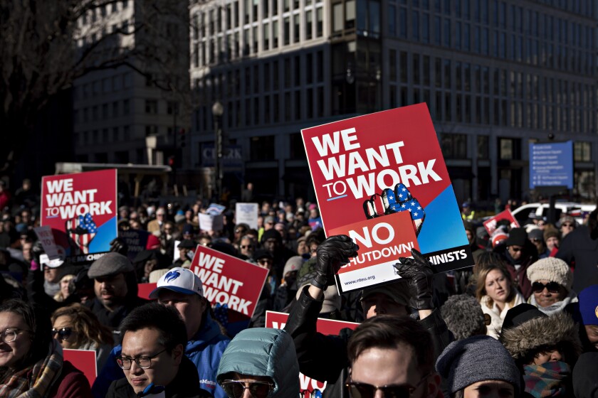 A demonstrator holds a "We Want To Work" sign during a rally with union members and federal employees to end the partial government shutdown outside the American Federation of Labor & Congress of Industrial Organizations (AFL-CIO) headquarters in Washington, D.C., U.S., on Thursday, Jan. 10, 2019. The partial government shutdown entered its 20th day today as its impact is more widely felt with about 800,000 federal workers who will miss their paychecks on Friday.