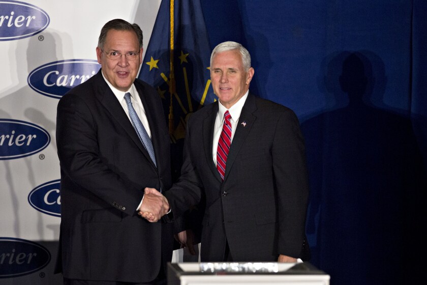 Gregory Hayes, president and chief executive officer of United Technologies Corp., left, shakes hands with U.S. Vice President-elect Mike Pence during an event at Carrier Corp. in Indianapolis, Indiana, U.S., on Thursday, Dec. 1, 2016.
