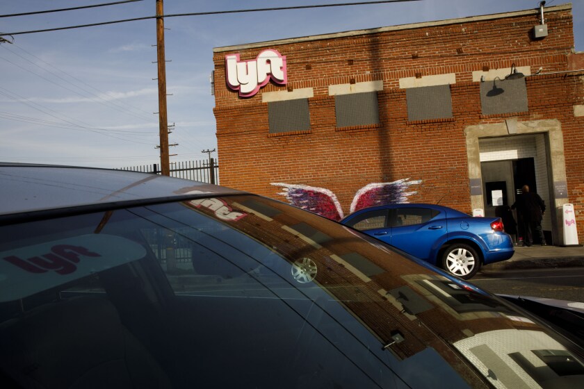 Vehicles sit parked outside the Lyft Inc. driver hub in Los Angeles.