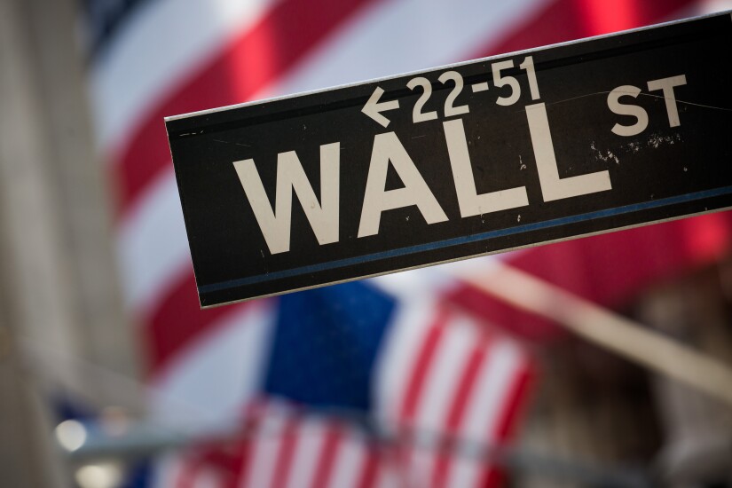 Wall Street sign with American flags Bloomberg photo
