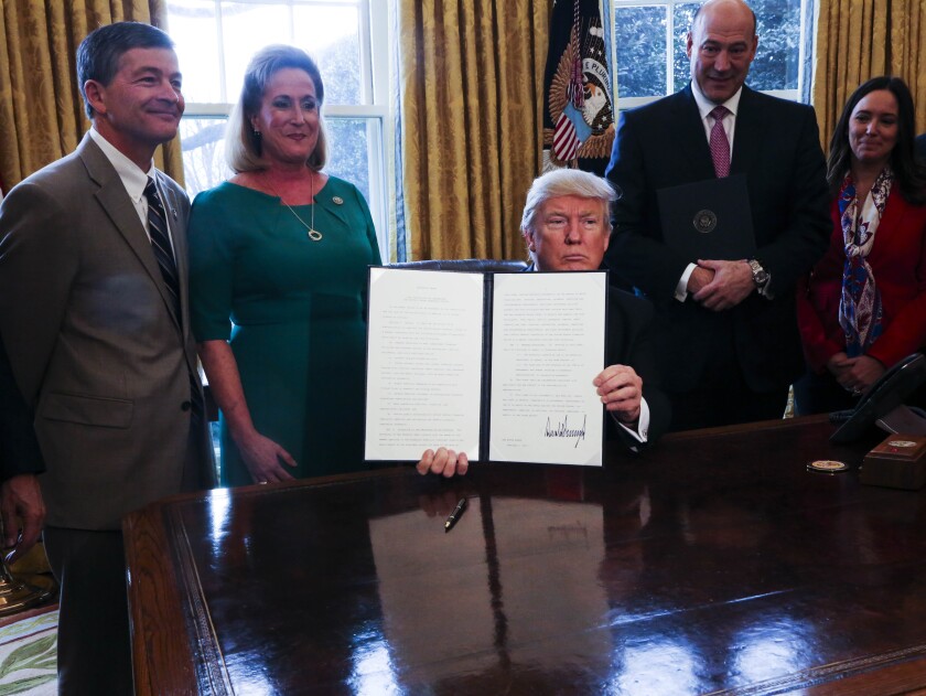 President Trump with members of Congress signing Dodd-Frank and fiduciary executive order Bloomberg News