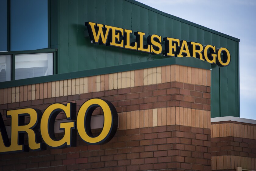 Signage is displayed outside a Wells Fargo & Co. bank branch in Palatine, Illinois, U.S., on Tuesday, July 10, 2018. Wells Fargo & Co. is scheduled to release earnings figures on July 13.