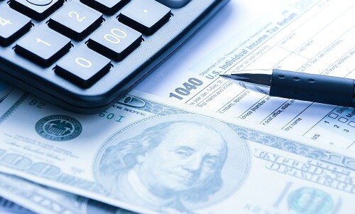 Tax form financial concept with some money and some other business objects aside.