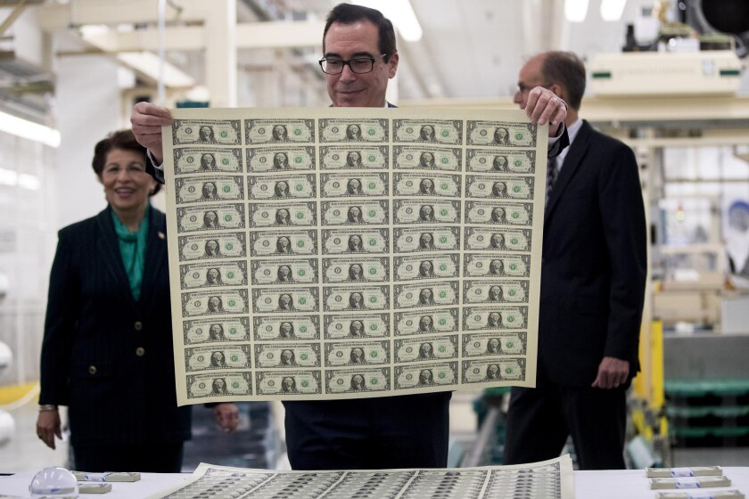 Treasury Secretary Steven Mnuchin views an uncut sheet of $1 notes bearing his name at the U.S. Bureau of Engraving and Printing in Washington, D.C.