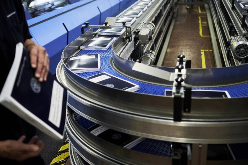 Copies of the fiscal year 2018 budget move along a conveyor belt during the binding process inside the Government Publishing Office