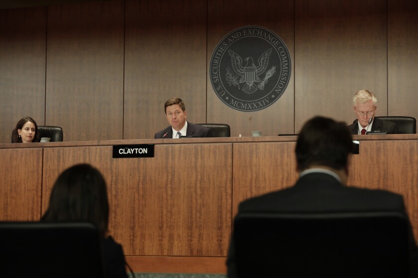 Jay Clayton, chairman of U.S. Securities and Exchange Commission (SEC), center, speaks during an SEC open meeting in Washington, D.C., U.S., on Wednesday, April 18, 2018. Clayton unveiled a new approach that will attempt to address legal and regulatory uncertainties that were largely triggered by the Labor Department's rules